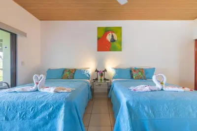 two swans are sitting on the beds in a room at Hotel Villas de la Selva in Manuel Antonio