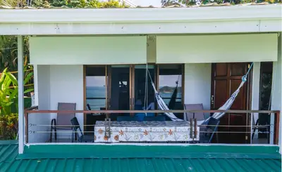 a porch of a house with a table and chairs at Hotel Villas de la Selva in Manuel Antonio