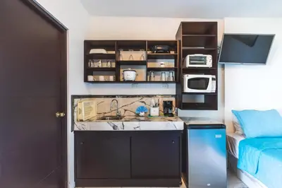 a small kitchen with a sink and a microwave at Hotel Villas de la Selva in Manuel Antonio
