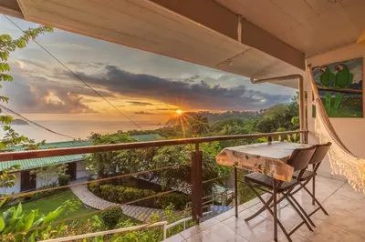 a view of the ocean from the balcony of a house at Hotel Villas de la Selva in Manuel Antonio