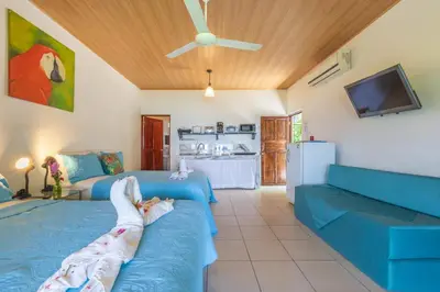a living room with two beds and a couch at Hotel Villas de la Selva in Manuel Antonio