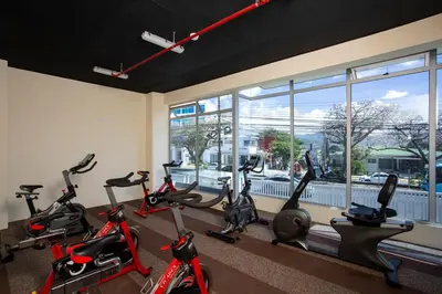 a row of exercise bikes in a gym with a window at Luxury Escape 1 Bedroom & 1 Bathroom c404 Tly in San José