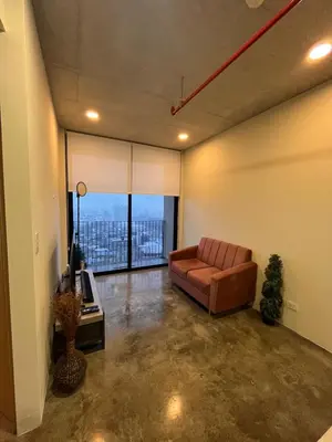 a living room with a couch and a large window at Evening Breeze in San José