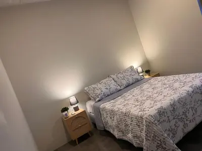 a small bedroom with a bed and two lamps at Evening Breeze in San José