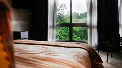 a bedroom with a bed and a large window at Dar Lamia Boutique Hotel in Manuel Antonio
