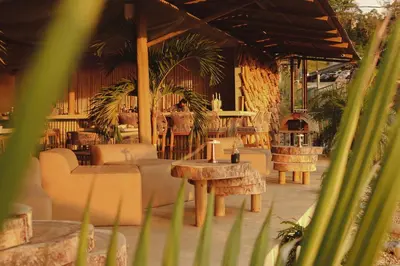 a restaurant with tables and chairs and a person in the background at Dar Lamia Boutique Hotel in Manuel Antonio