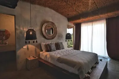 a bedroom with a bed and a mirror on the wall at Dar Lamia Boutique Hotel in Manuel Antonio