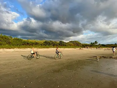 two people riding bikes on a beach with a dog at Villa Casa Modelo in Marbella