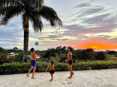a group of people playing with a ball under a palm tree at Villa Casa Modelo in Marbella