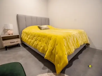 a bed with a yellow blanket on it in a room at Tropical Apartment URBN Escalante in San José