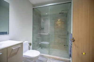 a bathroom with a toilet and a glass shower at Tropical Apartment URBN Escalante in San José