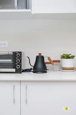 a tea kettle on a counter next to a microwave at Vistas a la montaña 1301 URBN in San José