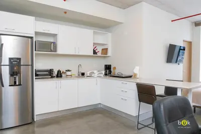 a kitchen with white cabinets and a stainless steel refrigerator at Vistas a la montaña 1301 URBN in San José