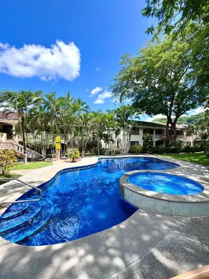 a swimming pool with blue water in a yard at Casa Suerte in Coco