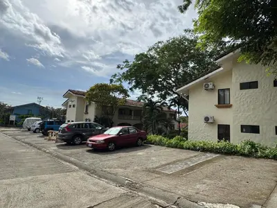 two cars parked in a parking lot next to a building at Casa Suerte in Coco