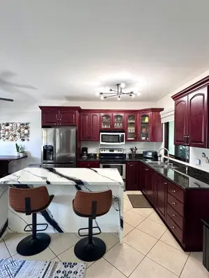 a kitchen with red cabinets and a white counter top at Casa Suerte in Coco