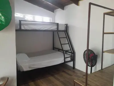 a room with two bunk beds and a mirror at Apartamentos GoZu # 1 in Puerto Viejo