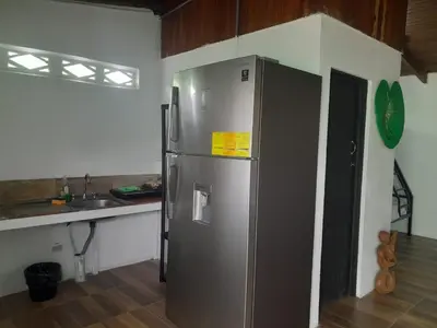 a kitchen with a stainless steel refrigerator and a sink at Apartamentos GoZu # 1 in Puerto Viejo