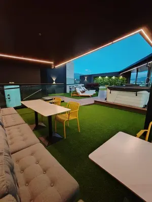 a living room with a table and chairs on a roof at Balcony Sunset in San José