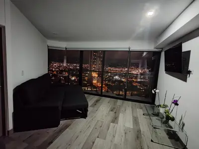 a living room with a view of a city at Balcony Sunset in San José