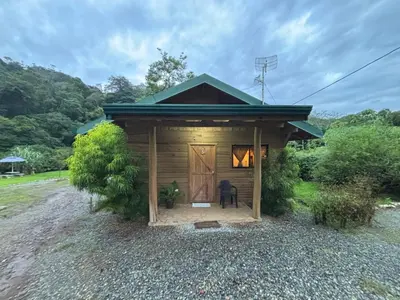 a small shed with a door and a chair in front at Cabaña Jacaranda #1, San Isidro, Pérez Zeledón in Roble