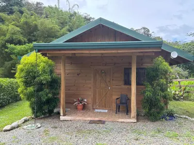 a wooden shed with a chair in front of it at Cabaña Jacaranda #2, junto al río, San Isidro, Pérez Zeledón in Roble