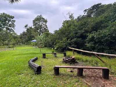 a park with two benches and a fire pit at Cabaña Jacaranda #2, junto al río, San Isidro, Pérez Zeledón in Roble