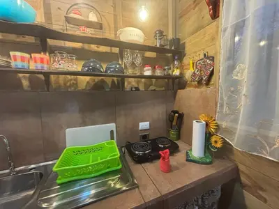 a kitchen counter with a green tray on a sink at Cabaña Jacaranda #2, junto al río, San Isidro, Pérez Zeledón in Roble