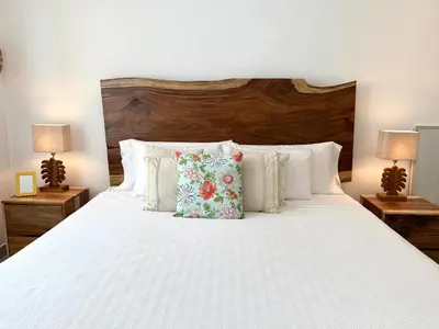 a bedroom with a large white bed with two lamps at Grandy Oasis Villa with Private Pool in Coco