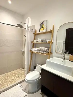 a bathroom with a sink and a toilet and a mirror at Grandy Oasis Villa with Private Pool in Coco