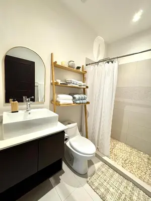 a bathroom with a sink and a toilet and a mirror at Grandy Oasis Villa with Private Pool in Coco