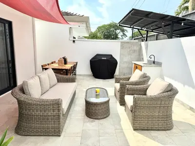 a patio with wicker chairs and a table at Grandy Oasis Villa with Private Pool in Coco