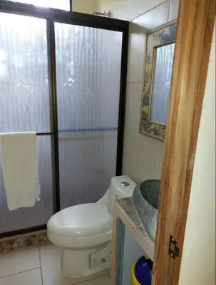 a small bathroom with a toilet and a shower at La Paz in Bahia