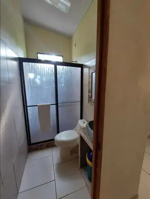 a bathroom with a toilet and a sink and a window at La Paz in Bahia