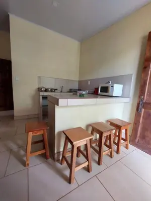 a kitchen with three wooden tables and a counter at La Paz in Bahia