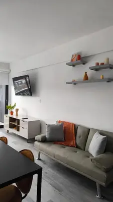 a living room with a couch and shelves on the wall at Alma Verde Escalante 605 in San José