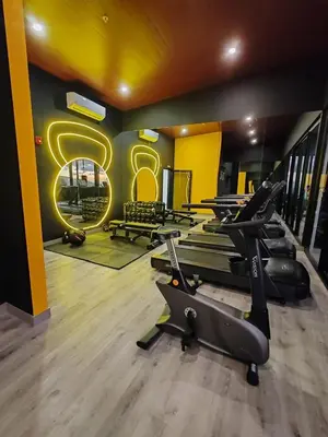 a gym with a row of treadmills and a sign at Alma Verde Escalante 605 in San José
