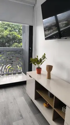 a living room with a table and a large window at Alma Verde Escalante 605 in San José