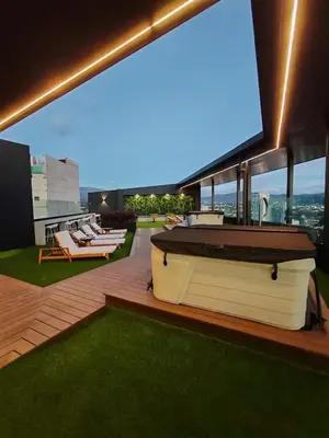 a building with a pool and lounge chairs on the roof at Alma Verde Escalante 605 in San José