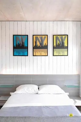 a bedroom with four pictures on the wall above a bed at ART AND STYLE Wonderful space for a couple in San José