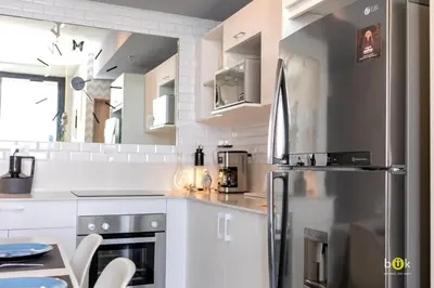 a kitchen with a stainless steel refrigerator and white cabinets at ART AND STYLE Wonderful space for a couple in San José