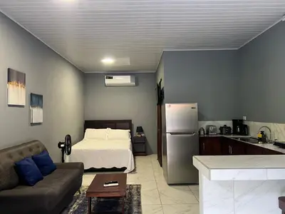 a living room with a bed and a kitchen at Apartamentos zafiro in Bahia