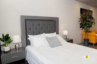 a bedroom with a large white bed with two lamps at Cozy New Studio Excellent Location in San José