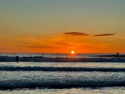 people surfing in the ocean at sunset at Casa Dorada 55 Studio in Marbella