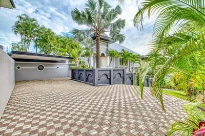 an exterior view of a house with palm trees at Castillo Colonial Nosara - by Pura Villas in Nosara
