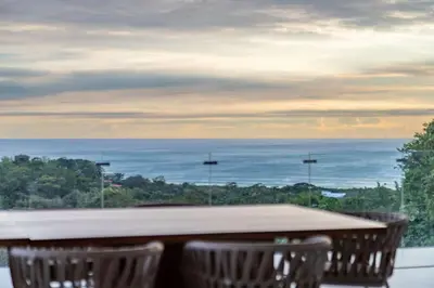 a table with chairs and a view of the ocean at Casa Vivo in Nosara