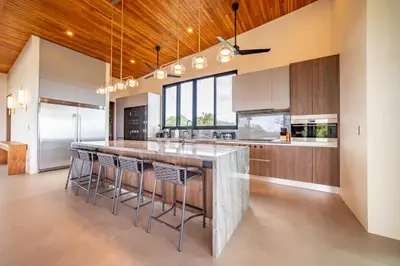 a kitchen with a large island with bar stools at Casa Vivo in Nosara