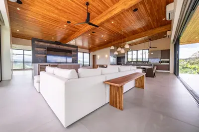 a living room with a white couch and a tv at Casa Vivo in Nosara