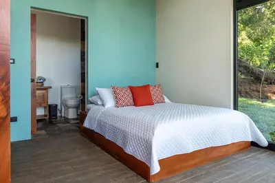 a bedroom with a bed with red pillows on it at CasaYvyra 'i in Sierra
