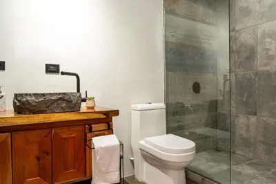 a bathroom with a toilet and a glass shower at CasaYvyra 'i in Sierra